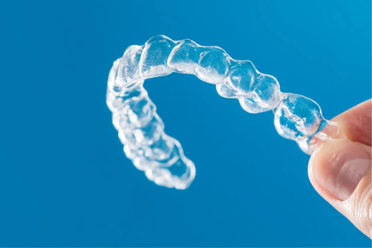 Close-up_of_a_person_holding_a_dental_retainer_479e4d04-906c-4842-9909-7f7c87d1f893