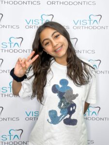 Girl with braces doing a peace sign