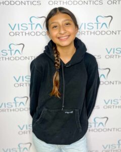 Girl posing in front of Vista Ortho background