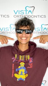 Young man with sunglasses that have New Smile written on them